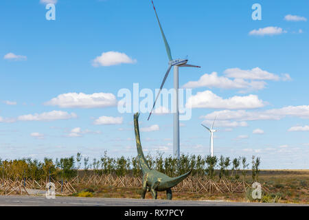 Erenhot, Chine - 23 septembre 2018 dinosaure : sculpture de métal. Dinosaur regarde le générateur de vent dans la steppe. Banque D'Images