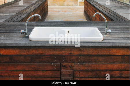 Lavabo en porcelaine situé dans une plate-forme de bois à l'extérieur dans un jardin de style moderne Banque D'Images