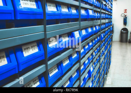 Plastique bleu tire de stock / parts dans les rangées d'étagères dans un entrepôt Banque D'Images