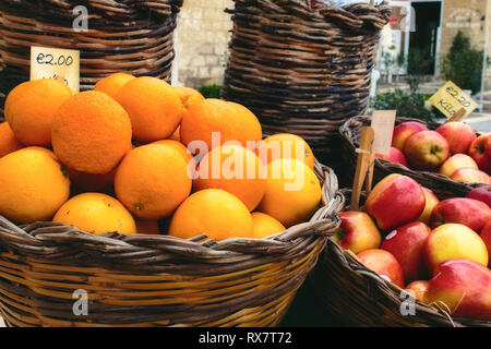 Vendeur marché panier avec des fruits dans les paniers en osier Banque D'Images