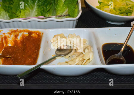 Des petits bols de trois sauces, trempettes assorties sur un buffet de cuisine asiatique Banque D'Images