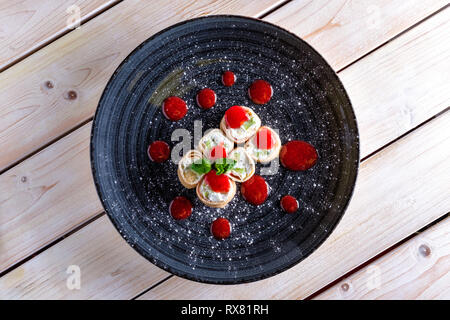 Crêpes farcies au fromage et kiwi décorées avec de la confiture de fraise Banque D'Images