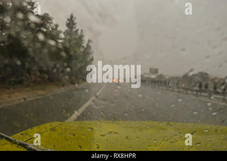 Déluge de pluie en un coup strom en roulant sur l'autoroute. La forte pluie sur le pare-brise et feux arrière dans la distance. Banque D'Images