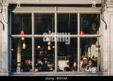 Londres, UK - Février 03, 2019 : vue par la fenêtre des gens dans Market Cafe pub sur Broadway Market, une rue commerçante en plein cœur de Hackney Banque D'Images