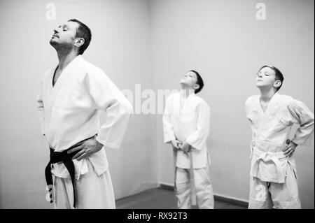 Les enfants en kimono commencer la formation sur l'aikido. Banque D'Images