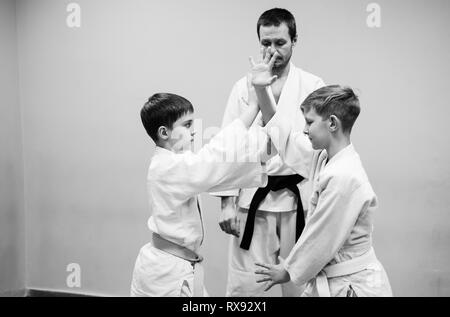 Les enfants en kimono commencer la formation sur l'aikido. Banque D'Images