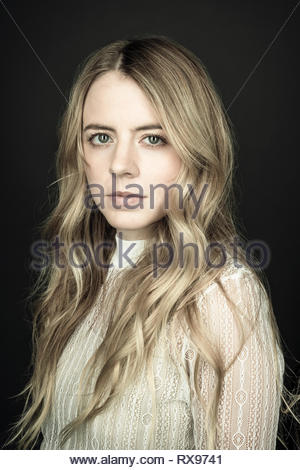 Portrait confiant belle jeune femme blonde aux yeux bleus