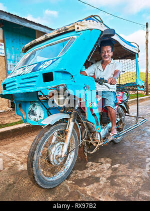 Taytay, la province de Palawan, Philippines : couleur bleu tricycle ancien avec le conducteur de la vieillesse près du marché humide Banque D'Images