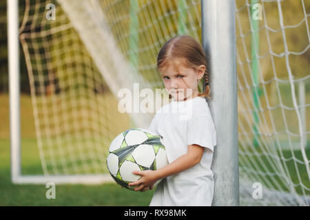 Petite fille heureuse sur terrain de football Banque D'Images