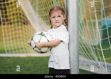 Petite fille heureuse sur terrain de football Banque D'Images