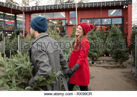 Heureux couple shopping pour arbre de Noël Marché de Noël
