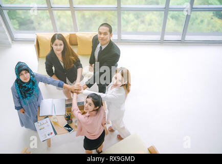 Vue du dessus de la pile de l'équipe de mains ensemble pendant que l'unité et de l'équipe au pouvoir. Young Asian businessman et la solidarité du groupe collaboration Banque D'Images