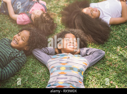 Heureux les enfants enfants portant sur l'herbe dans le parc Banque D'Images