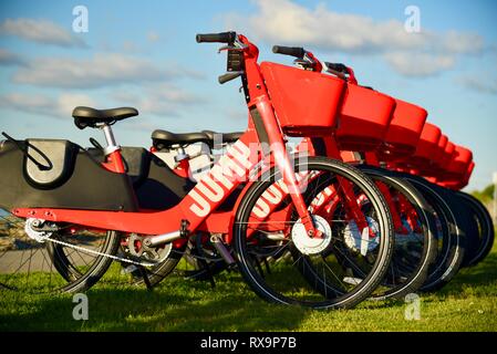 L'uber Jump le covoiturage (vélo partager) rouge, des vélos électriques (e-bikes) alignés sur l'herbe sur Harbour Island, San Diego, USA Banque D'Images