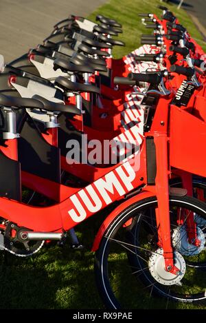 L'uber Jump le covoiturage (vélo partager) rouge, des vélos électriques (e-bikes) alignés sur l'herbe sur Harbour Island, San Diego, USA Banque D'Images