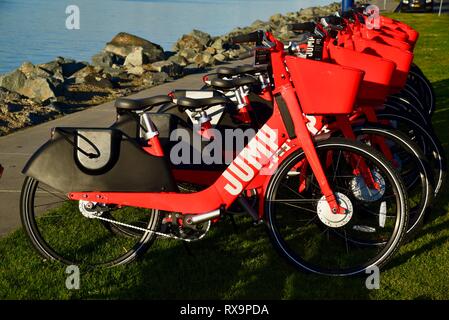 L'uber Jump le covoiturage (vélo partager) rouge, des vélos électriques (e-bikes) alignés sur l'herbe sur Harbour Island, San Diego, USA Banque D'Images