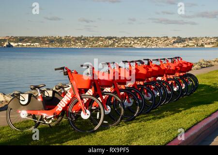 L'uber Jump le covoiturage (vélo partager) rouge, des vélos électriques (e-bikes) alignés sur l'herbe sur Harbour Island, San Diego, USA Banque D'Images