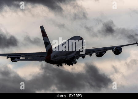 Avion de ligne à réaction superjumbo A380 de British Airways décollant de l'aéroport de Londres Heathrow par mauvais temps. Nuages de pluie sombres dans le ciel Banque D'Images