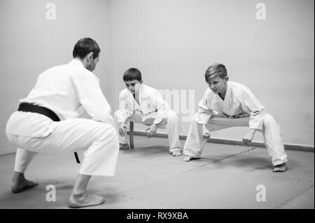 Les enfants en kimono commencer la formation sur l'aikido. Banque D'Images