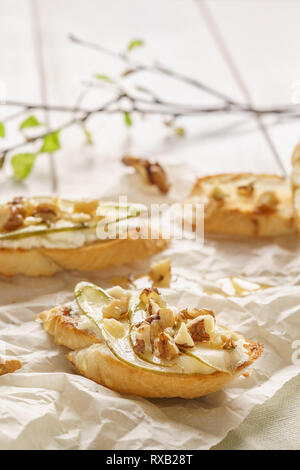 Crostini ou bruschetta à la ricotta, poire, noix et miel pour le petit déjeuner. Banque D'Images