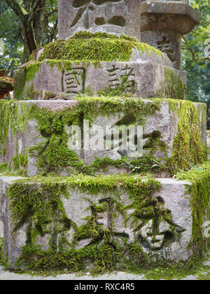 Nara, Japon - 15 octobre 2018 : les caractères japonais sur une ancienne structure de pierre moussue près du grand sanctuaire de Kasuga Nara, Japon. Banque D'Images