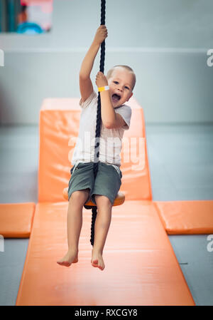 Cute kid boy sur zip line à jeux pour enfants Banque D'Images