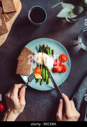 Vue de dessus sur le dîner ou déjeuner pour un, œuf poché sur grill les asperges et tomates cerises. Banque D'Images