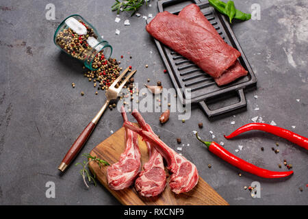 Ensemble de boeuf Black Angus non cuites brutes tomahawk sur des os et des steaks de veau farci servi avec du chili et de poivre. Style rustique. Close up Banque D'Images