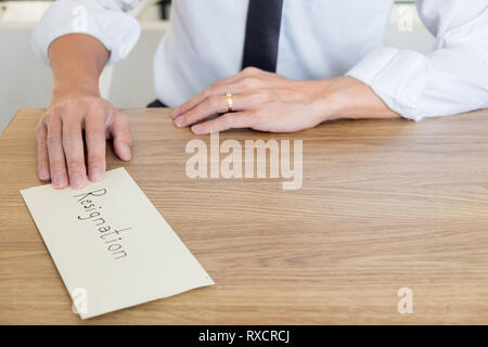 Un businessman et en envoyant une lettre de l'enveloppe sur une table en bois à son patron, changement d'emploi, le chômage concept. Banque D'Images