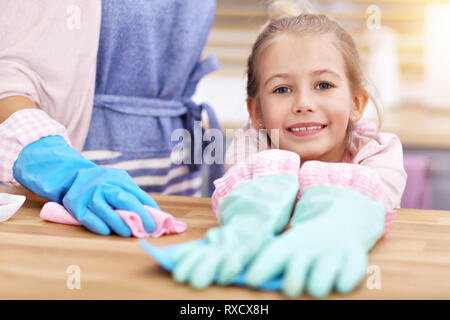 Petite fille et sa maman dans la cuisine nettoyage des tabliers Banque D'Images