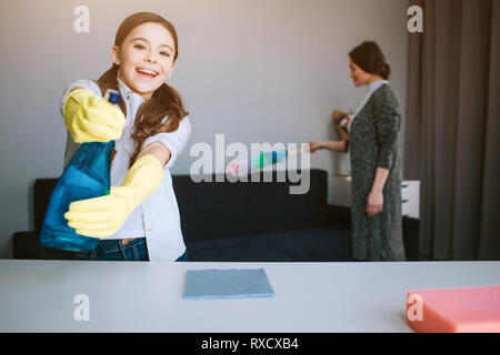 Belle brune portrait mère et fille ensemble de nettoyage dans la chambre. Funny Girl Nice rechercher sur caera et utilisation psray sur elle. Elle joue. Sa maman Banque D'Images