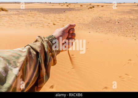 La main des hommes est coulée en sable chute désert du Sahara Banque D'Images