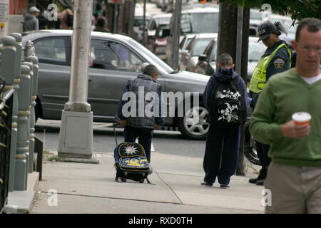 Les enfants de l'école attendant pour traverser la rue à côté d'un brigadier scolaire à Jersey City, NJ, USA Banque D'Images