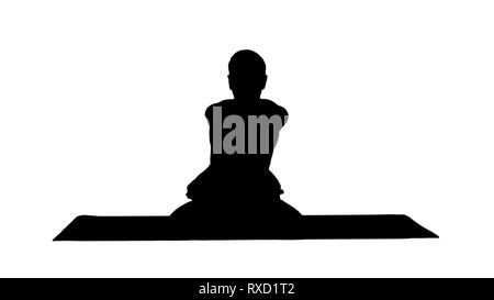Silhouette beau jeune homme sportif pratiquant le yoga, assis en tailleur dans Adho Mukha le Padmasana, flexion de l'avant dans la variation de Lotus. Banque D'Images