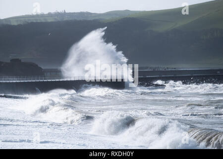 Aberystwyth, Pays de Galles, Royaume-Uni. 9 Mar 2019. Météo France : des coups de vent avec rafales à plus de 60 mi/h et le matin de la moissonneuse-batteuse de la marée haute, portant d'énormes vagues déferle sur la mer d'Irlande à la mer la pâte à Aberystwyth, sur la défense de la côte de la Baie de Cardigan, West Wales UK Crédit : Keith morris/Alamy Live News Banque D'Images