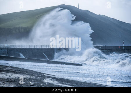 Aberystwyth, Pays de Galles, Royaume-Uni. 9 Mar 2019. Météo France : des coups de vent avec rafales à plus de 60 mi/h et le matin de la moissonneuse-batteuse de la marée haute, portant d'énormes vagues déferle sur la mer d'Irlande à la mer la pâte à Aberystwyth, sur la défense de la côte de la Baie de Cardigan, West Wales UK Crédit : Keith morris/Alamy Live News Banque D'Images