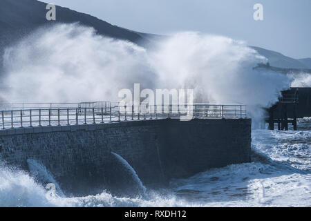 Aberystwyth, Pays de Galles, Royaume-Uni. 9 Mar 2019. Météo France : des coups de vent avec rafales à plus de 60 mi/h et le matin de la moissonneuse-batteuse de la marée haute, portant d'énormes vagues déferle sur la mer d'Irlande à la mer la pâte à Aberystwyth, sur la défense de la côte de la Baie de Cardigan, West Wales UK Crédit : Keith morris/Alamy Live News Banque D'Images