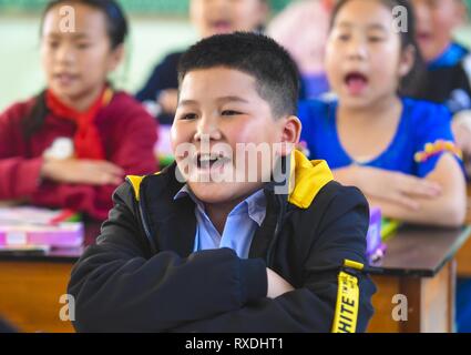 Ruili, province chinoise du Yunnan. Mar 8, 2019. Un étudiant birman récite la poésie en classe à l'école primaire de Yinjing Yinjing Village de Ruili, sud-ouest de la province chinoise du Yunnan, le 8 mars 2019. L'école primaire Yinjing est située à la frontière de la Chine et le Myanmar et il dispose d'un total de 135 étudiants, dont 36 étudiants du Myanmar. Crédit : Li Xiaoguo/Xinhua/Alamy Live News Banque D'Images