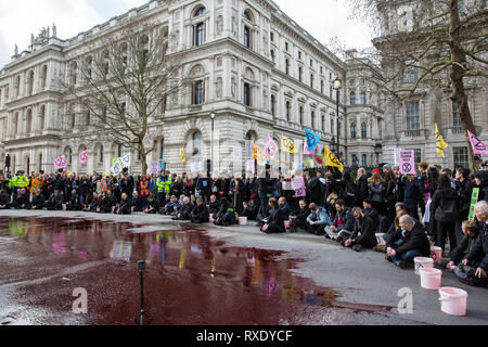 Londres, Royaume-Uni. Mar 9, 2019. Activistes du climat de l'extinction pour rébellion sang artificiel sur le sol hors de Downing Street dans le cadre d'un acte de désobéissance civile nommé "Le sang de nos enfants" pour appeler le gouvernement à prendre des mesures immédiates pour lutter contre le climat actuel et l'urgence écologique. Credit : Mark Kerrison/Alamy Live News Banque D'Images