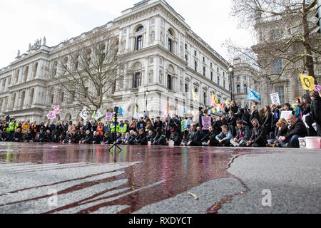 Londres, Royaume-Uni. Mar 9, 2019. Activistes du climat de l'extinction pour rébellion sang artificiel sur le sol hors de Downing Street dans le cadre d'un acte de désobéissance civile nommé "Le sang de nos enfants" pour appeler le gouvernement à prendre des mesures immédiates pour lutter contre le climat actuel et l'urgence écologique. Credit : Mark Kerrison/Alamy Live News Banque D'Images