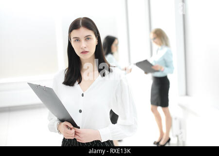Femme d'affaires exécutif avec clipboard standing in office Banque D'Images