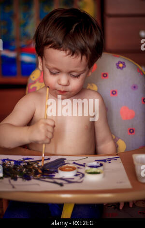 Garçon peint sur papier. Les activités des enfants. Hobby - dimensions. petit garçon attire. Dessin pour enfants Banque D'Images