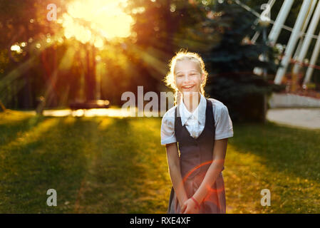 Les jeunes girlie, danser et sauter de joie s'amusant dans le parc au coucher du soleil Banque D'Images