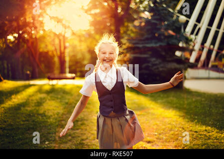 Les jeunes girlie, danser et sauter de joie s'amusant dans le parc au coucher du soleil Banque D'Images