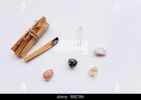 Un ensemble de bâtons de bois palo santo sur un fond blanc. A proximité, pierres spéciales - minéraux. Ils sont utilisés dans des cérémonies religieuses. Banque D'Images