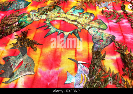 Tissu coloré avec des feuilles, des fougères et des formes de papier découpées demonstraiting comment créer tie dye designs, Bora Bora, Polynésie française. Banque D'Images