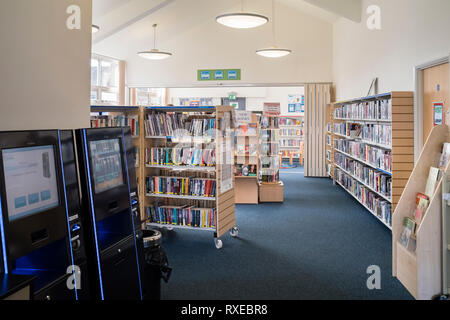 Un petit village de l'intérieur de la succursale de la bibliothèque publique de livres et de retrait électronique/retour, Wellesbourne, Royaume-Uni. Banque D'Images