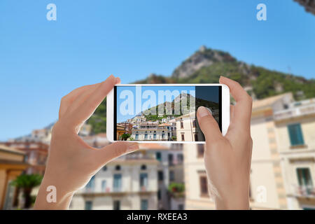 Un touriste prend une photo de la ville de Amalfi de l'escalier de la Duomo local dans un clair d'été journée ensoleillée sur un téléphone mobile Banque D'Images