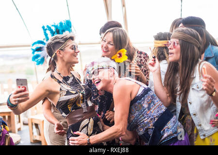 Groupe de hippies caucasian belles femmes à la recherche d'un smartphone pour voir une photo ou internet résultats sur le web. belle belle les gens restent ensemble Banque D'Images