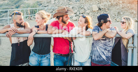 Groupe de jeunes amis et permanent à l'autre s'amusant pour l'amitié - l'été et millénaire d'autres gens souriants et plein air laughi Banque D'Images